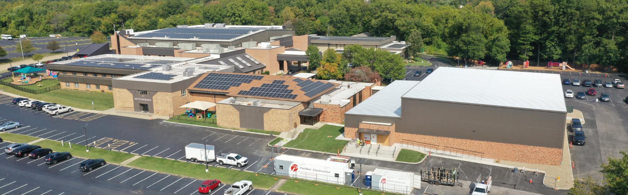 First Baptist_Website Hero_2000x621 long exterior church/school building with tan brick and solar panels