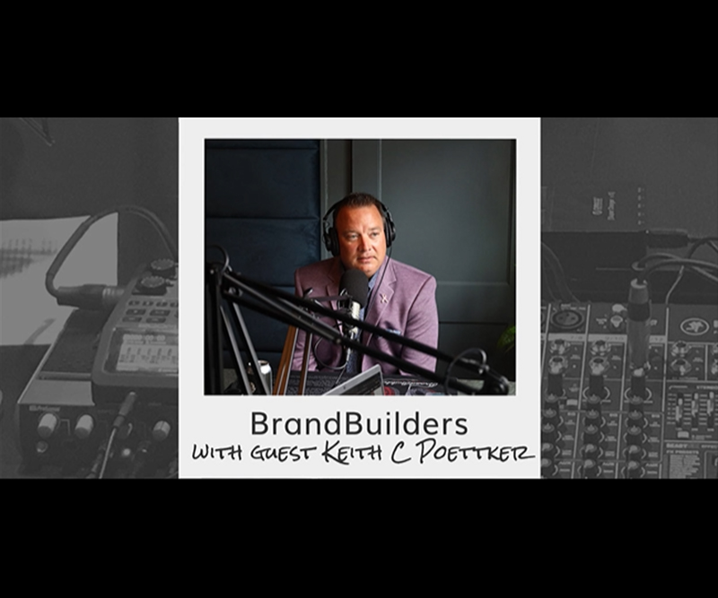 Keith Poettker in a sports coat and headphones at a radio studio