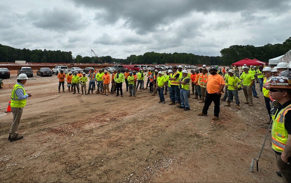 A Project manager addresses his team at a construction site.