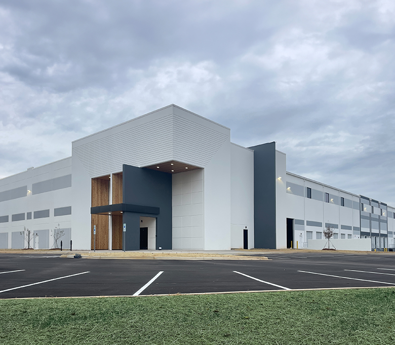 Exterior of a warehouse building with a cloudy sky