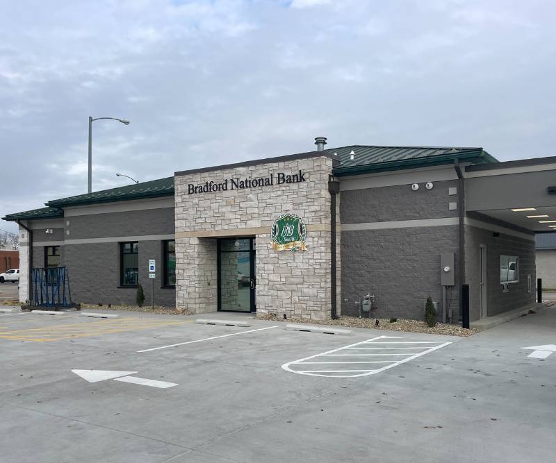 Exterior of a bank with a stone facade on a cloudy day