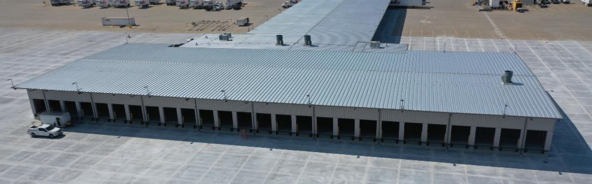 FedEx STL Expan__Website Hero_2000x621 an aerial view of a warehouse with many dock doors
