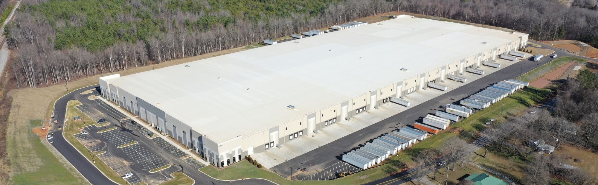 I-85 Commerce Bldg 1_Website Hero_2000x621 Aerial view of a large white distribution center