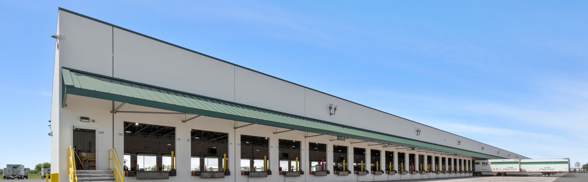R+L Cross Dock Sauget IL_Website Hero_2000x621 A distribution center with a green awning and open dock doors