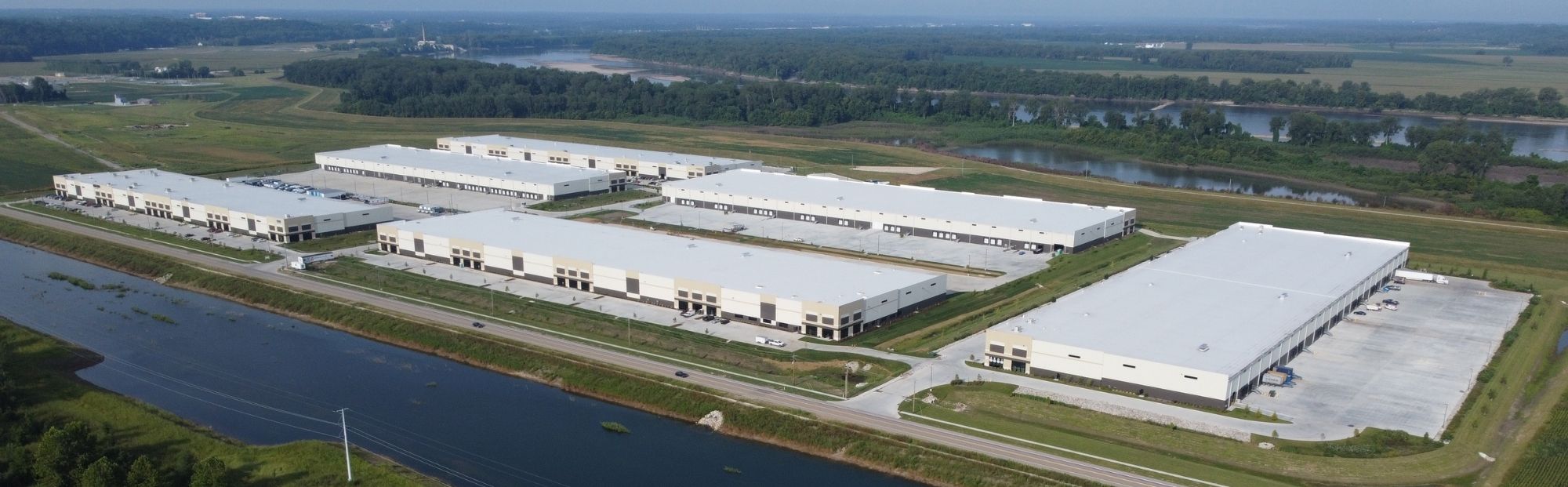 Westport Commerce_Bldg 4, 5 & 6_Website Hero_2000x621 Aerial view of neighboring white distribution centers