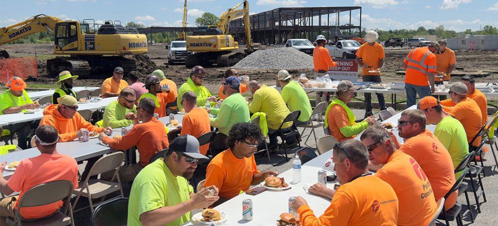 safetyweek2025-primary Men in vests eating lunch outside