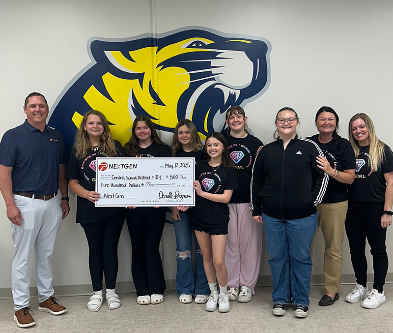 A group of students and faculty holding a large check