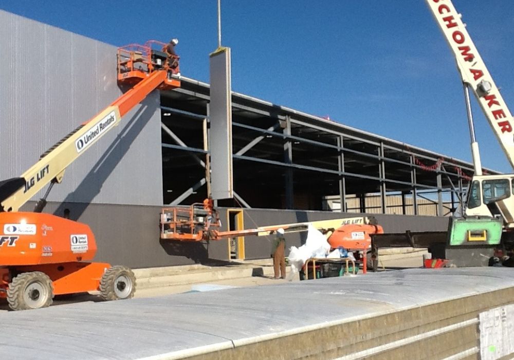 Construction equipment outside a halfway-built facility