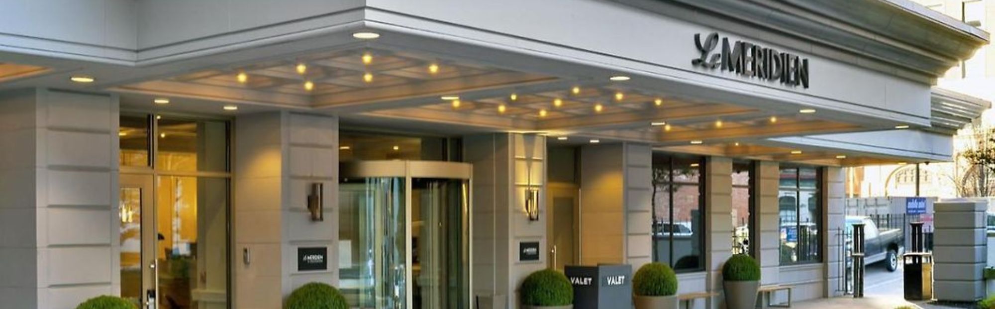 Le Meridien STL Marriott_Website Hero_2000x621 Exterior view of the Le Meridien St.. Louis Marriott entrance featuring columns and glass doors