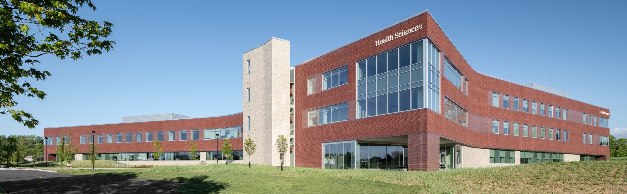 SIUE Health Science Complex_Website Hero_2000x621 long, multi-story red brick exterior health science building with windows