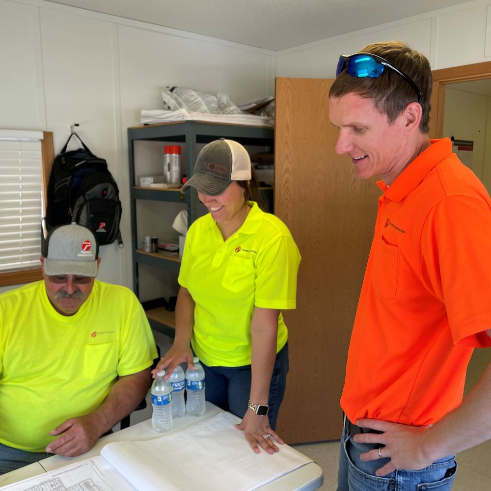 poettker-approach-construction-plan-review Two men and a woman inspect a building plan
