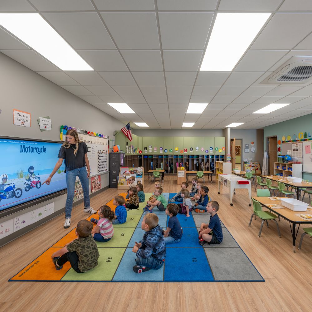 poettker-approach-kids-in-classroom A teacher points to motorcyclists on a monitor as young students watch