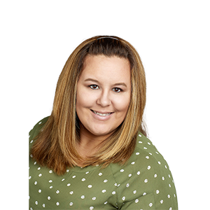 A smiling woman with dirty blonde hair in a green shirt with white polka-dots