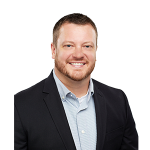 A smiling man with a scruffy beard in a dark blazer