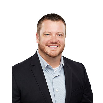 A bearded man in a collared shirt and dark blazer