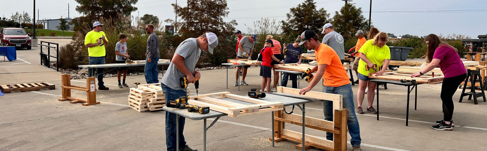 Men, women, and kids sawing and drilling wood