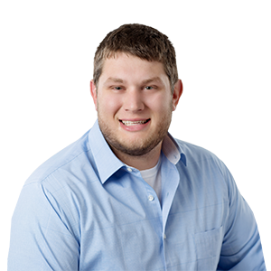 A smiling man in a light blue collared shirt