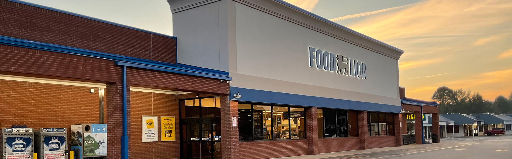 Exterior of a red brick grocery store at sunset