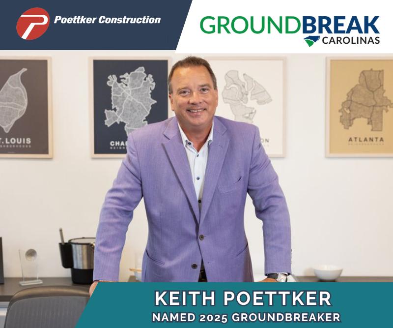 A man standing behind a conference table with each hand resting on a different conference chair