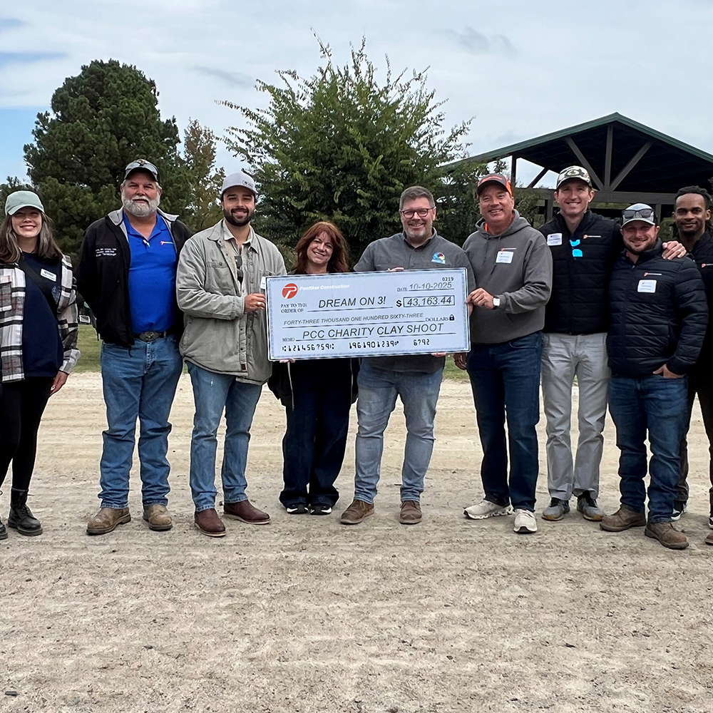 Poettker-Clay-Shoot-2025-Community A dozen men and women holding an oversized check