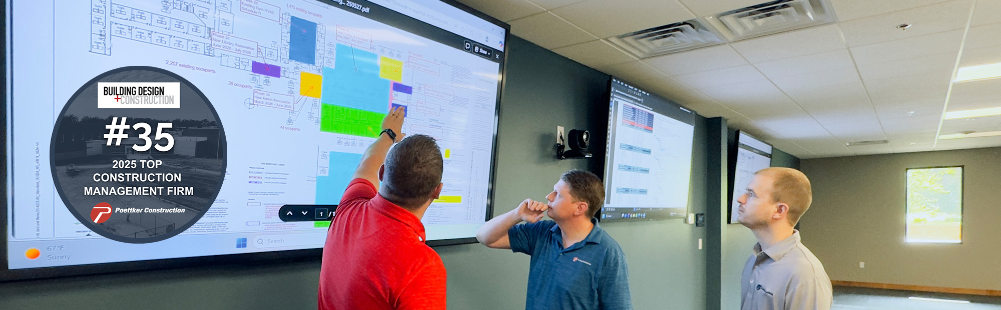 construction-management-services-2025 Three men reviewing a building plan on a large monitor