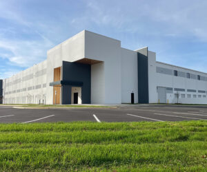 Exterior of a large, white distribution center and warehouse with a modern entrance 