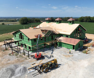 Aerial view of a distillery under construction with a wood roof