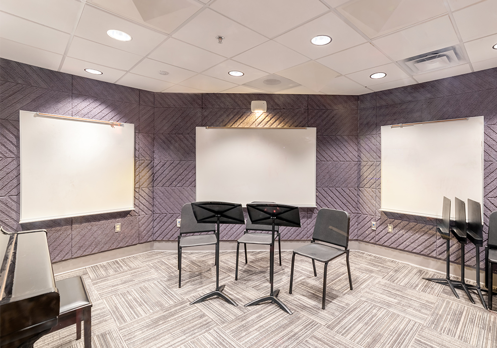 A music room with a piano and 3 white screens