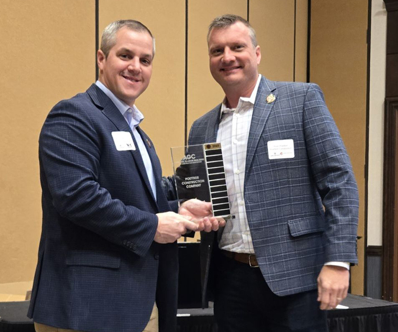 One man accepts a glass trophy from another man