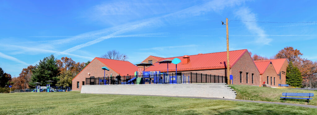 A school playground with an elementary school behind it