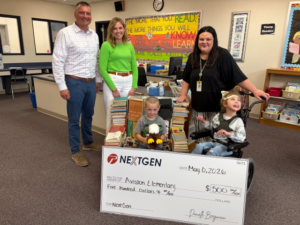 A man, two women and two children stand behind an oversized check