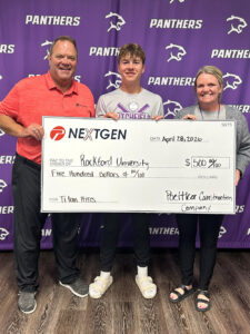 A male high school senior stands between a man and a woman, all holding an oversized check