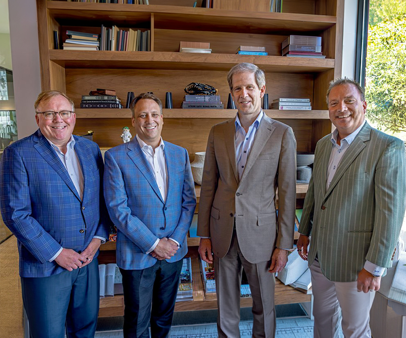 Four smiling men in sports coats