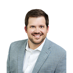 A smiling man with a beard in a plaid suit coat