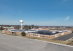 Aerial view of a brick middle school next to a water tower