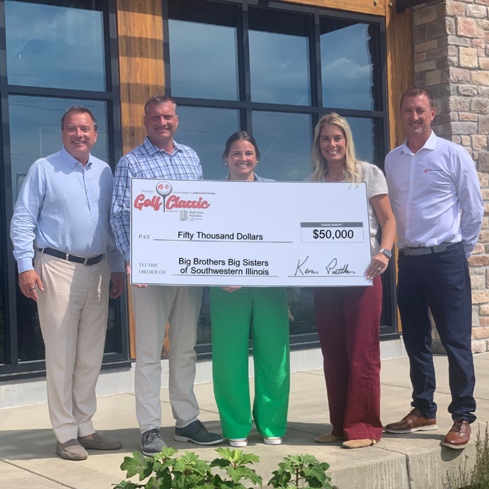 Poettker-Golf-Classic-Donation-2026-1000×1000 An oversized check is held by five adults outside a large corporate building
