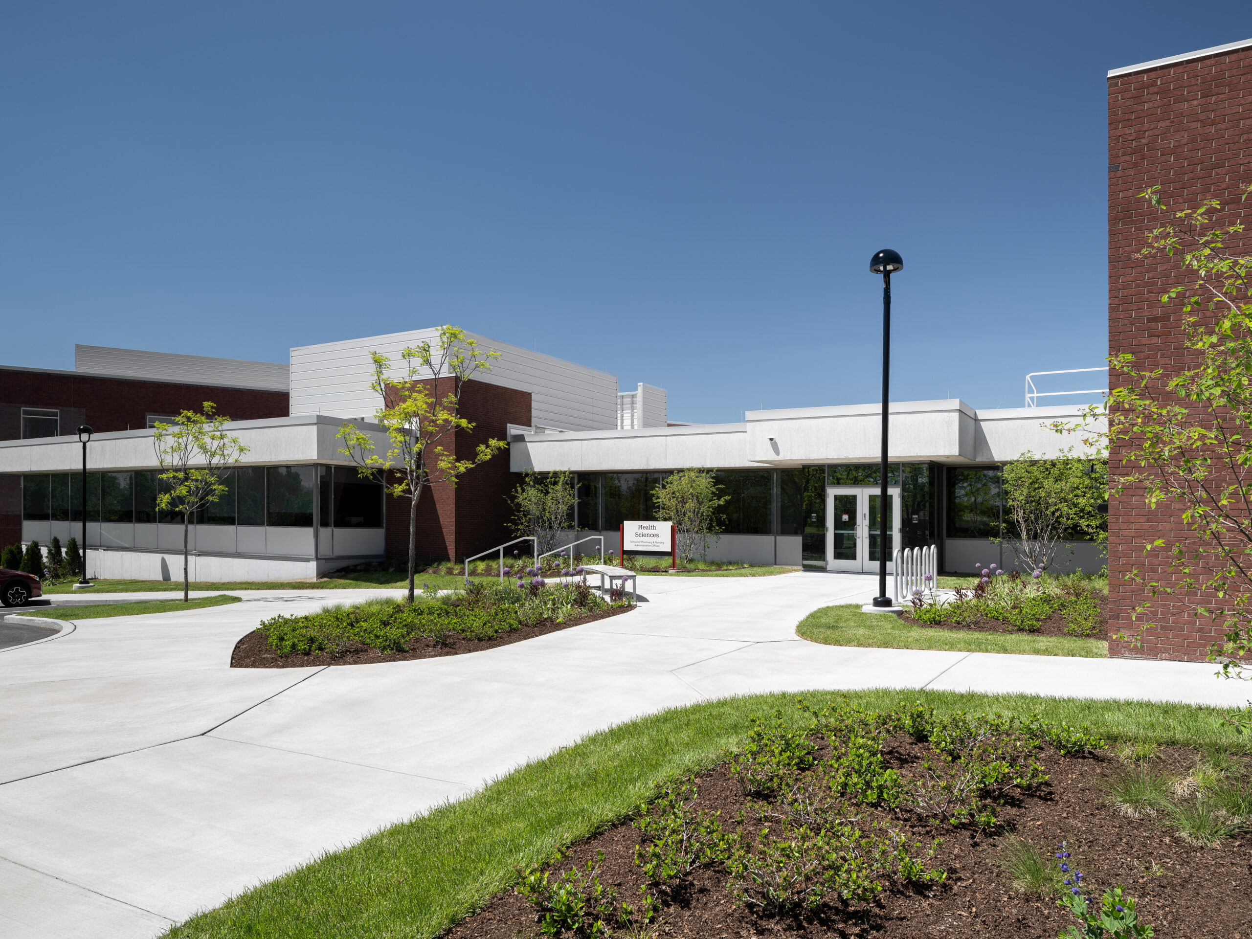 exterior high education building entrance with glass windows and brown brick