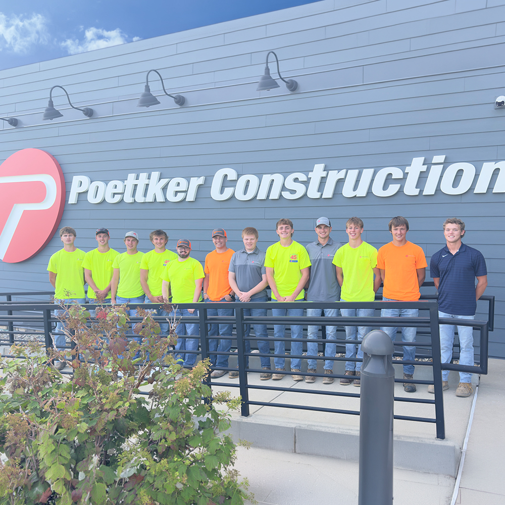 Men standing in front of a Poettker Construction sign