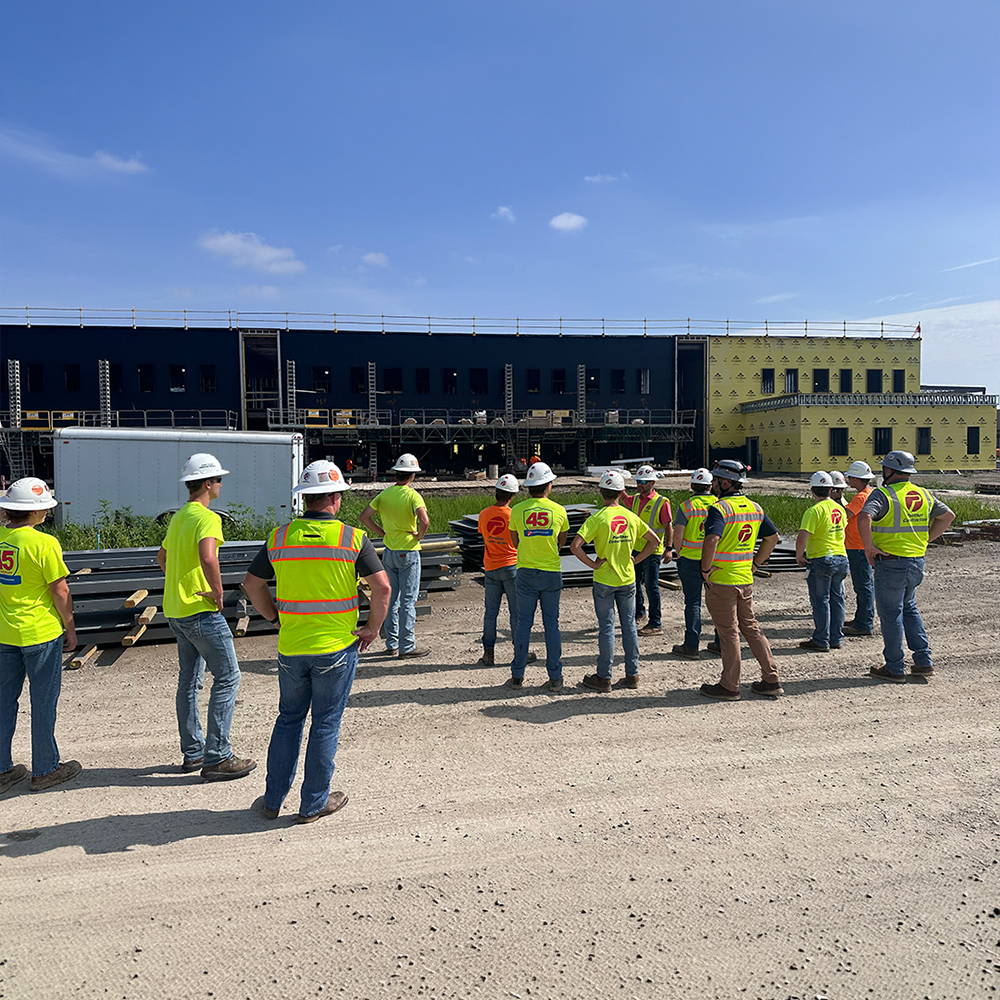 Men and women stand together at a construction site